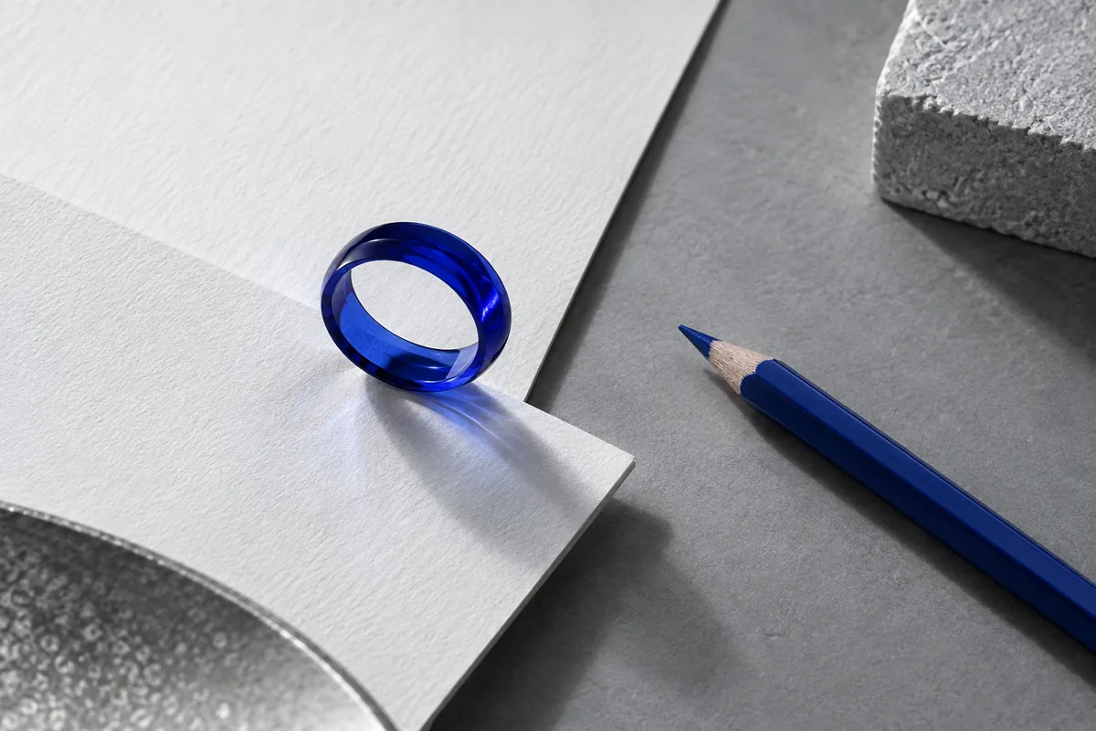 Blue glass lenses, paper and pencils illustrate research; this is not an office photograph